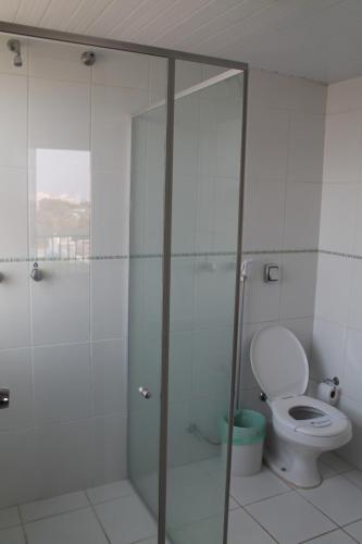 a bathroom with a toilet and a glass shower at Mato Grosso Palace Hotel in Cuiabá