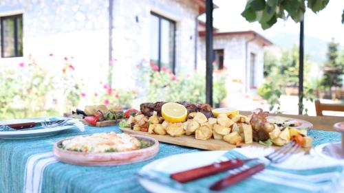 a table with a blue table cloth with food on it at Bujtina Adora in Ara të Lumit