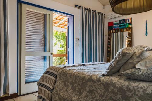 a bedroom with a bed and a window at Casa pé na areia na Praia da Armação em Ilhabela in Ilhabela