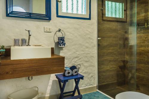 a bathroom with a shower and a sink and a toilet at Casa pé na areia na Praia da Armação em Ilhabela in Ilhabela