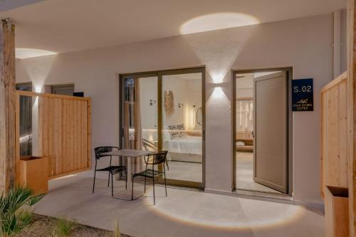 パノルモス・レティムノにあるCasa D'Oro Suites by Estia 'Adults Only'のテーブルと椅子、ベッドルーム1室が備わります。