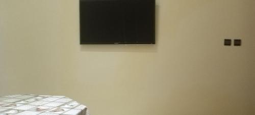 TV de pantalla plana en la pared de una habitación en Dar abd essalam, en Moulay Yacoub