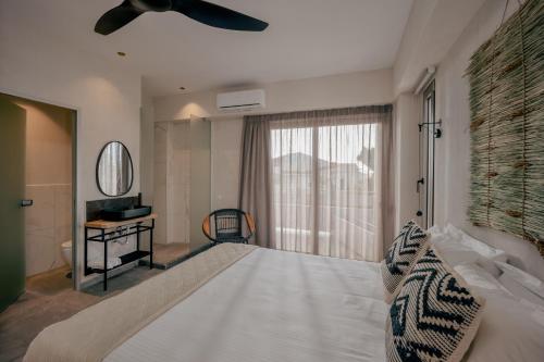 1 dormitorio con 1 cama blanca grande y ventana en Casa D'Oro Suites by Estia 'Adults Only', en Panormos Rethymno