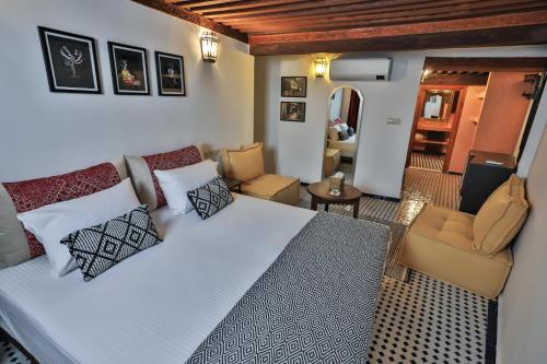 a bedroom with a large bed and a living room at Riad Moulaydriss et Giacomo in Fès