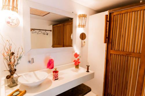uma casa de banho com um lavatório e um espelho em Bangalôs Meu Jardim Caraíva em Caraíva