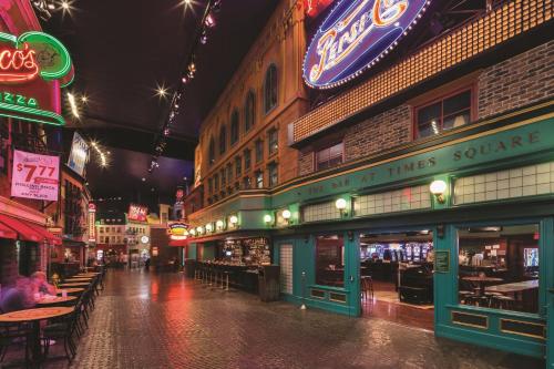 a city street at night with tables and neon signs at New York-New York in Las Vegas