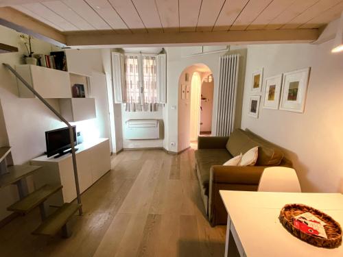 ein Wohnzimmer mit einem Sofa und einem TV in der Unterkunft Acacia Firenze - Giglio in Florenz
