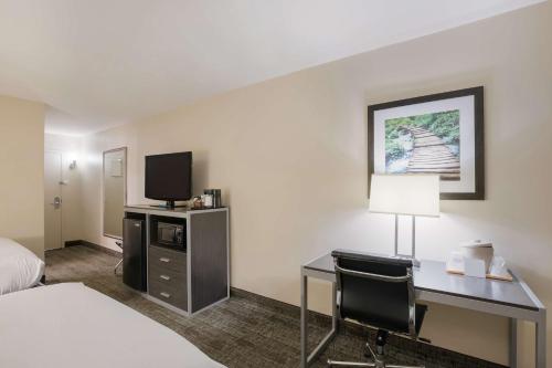 a hotel room with a desk and a tv at Best Western Northwest Indiana Inn in Hammond
