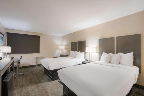 a hotel room with two beds and a desk at Best Western Northwest Indiana Inn in Hammond