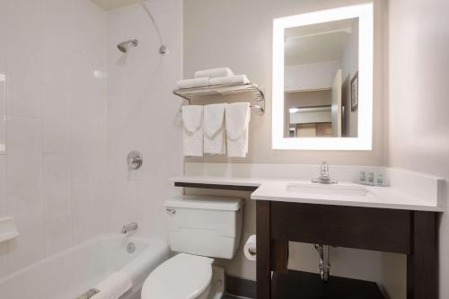 a bathroom with a toilet and a sink and a mirror at Best Western Northwest Indiana Inn in Hammond