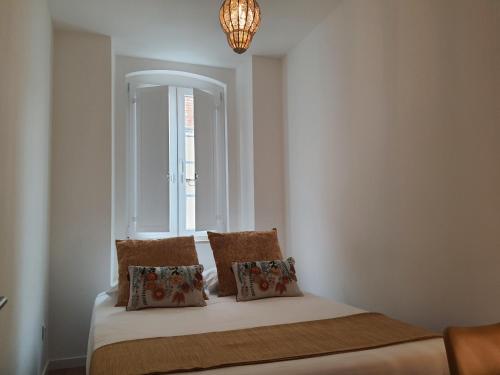 a bedroom with a bed with a window and a chandelier at Exotic Fusion: Coffee & Radio in Lisbon