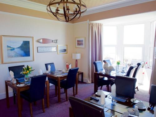 a meeting room with tables and chairs and a chandelier at Norland B & B in Lossiemouth