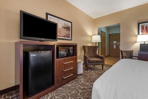 a hotel room with a bed and a flat screen tv at Best Western Plus Chelsea Hotel in Monticello