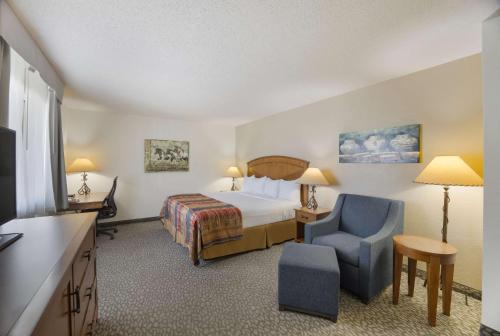 Habitación de hotel con cama y silla en Best Western Kokopelli Lodge, en Clayton