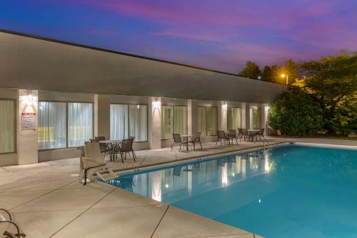 a pool with chairs and tables on a building at Best Western Plus University Inn in Winston-Salem