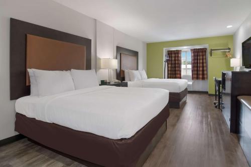 a hotel room with two beds and a television at SureStay Hotel by Best Western Shallotte in Shallotte