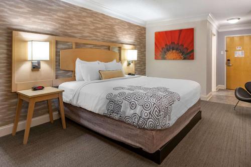 a hotel room with a large bed and a table at Best Western Plus University Inn in Winston-Salem
