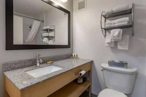 a bathroom with a sink and a toilet and a mirror at Best Western Plus University Inn in Winston-Salem