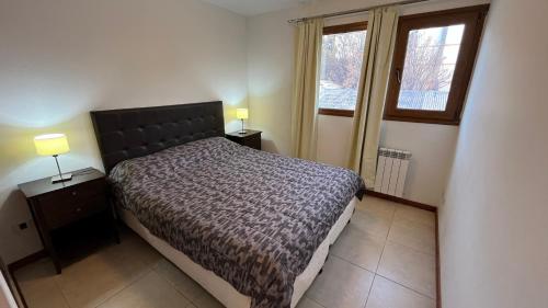 a bedroom with a bed and two night stands and a window at Apartamentos del Centro - BARILOCHE in San Carlos de Bariloche