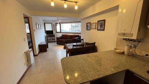 a kitchen and living room with a table and a counter top at Apartamentos del Centro - BARILOCHE in San Carlos de Bariloche