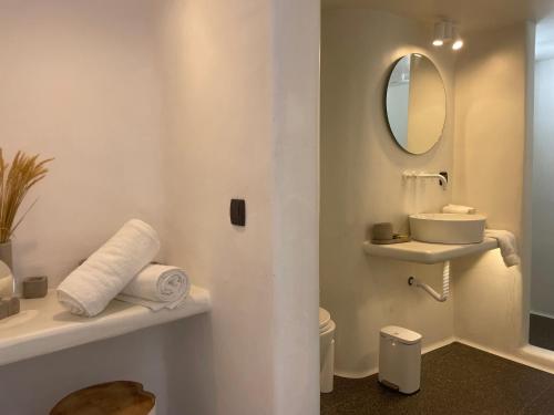 y baño con lavabo y espejo. en Nomikos Villas en Fira