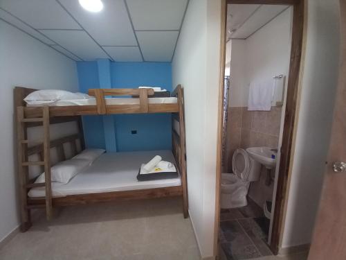 a small room with bunk beds and a bathroom at Ekolores Hostal 313-468-08-41 in Montenegro