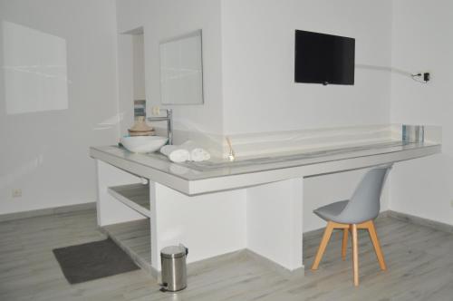 baño con lavabo y escritorio con silla en Keur de Pierre en Saly Portudal