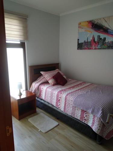 a bedroom with a bed and a table and a window at Sin fechas in Tomé