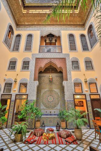 a room with a table in a building with plants at Riad Moulaydriss et Giacomo in Fès