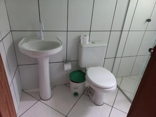 a small bathroom with a toilet and a sink at Pousada Cajueiro in Itaúnas