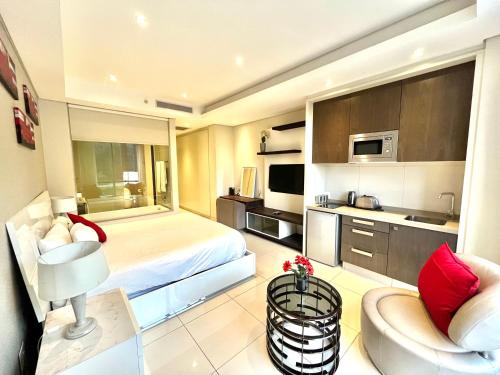 a hotel room with a bed and a kitchen at A cozy apartment at Sandton Skye in Johannesburg