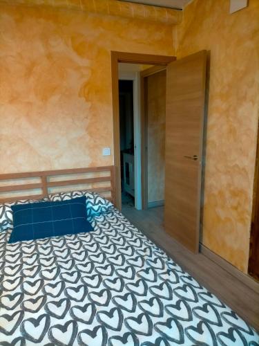 - une chambre avec un lit doté d'un oreiller bleu et d'une porte dans l'établissement Apartamento rural, à Miraflores de la Sierra