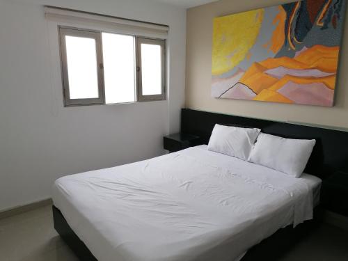 Un dormitorio con una cama blanca y una pintura en la pared en Apart Peru II, en Lima
