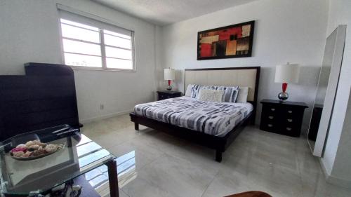 1 dormitorio con cama, mesa y ventana en Penthouse Ocean Reserve, en Miami Beach