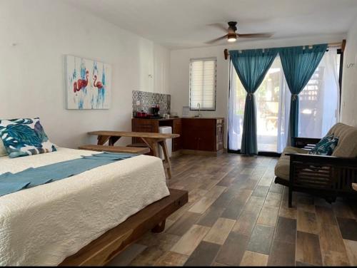 ein Schlafzimmer mit einem Bett, einem Tisch und einem Sofa in der Unterkunft Ah Muzenkab in El Cuyo