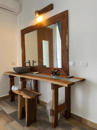 a bathroom with a wooden sink and a mirror at Ah Muzenkab in El Cuyo