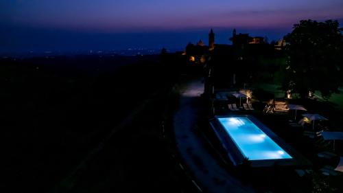 uma vista nocturna para uma piscina no escuro em Radice Verde em Cissone