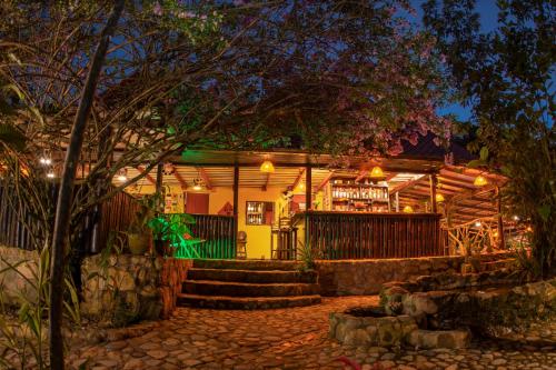 a building with a bar in front of it at night at Finca de la Vaca - Glamping in Palora