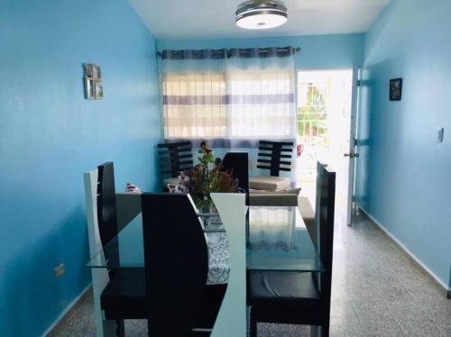uma sala de jantar com paredes azuis e uma mesa e cadeiras de vidro em Apto 2Habitaciones con Aire y Vista al Malecón de Samaná em Santa Bárbara de Samaná