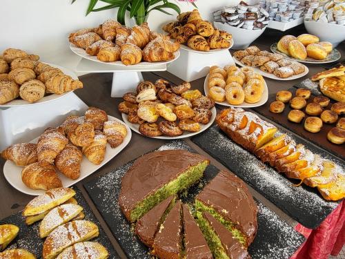 une table remplie de différents types de pâtisseries et de pain dans l'établissement Hotel Giannini, à Rimini