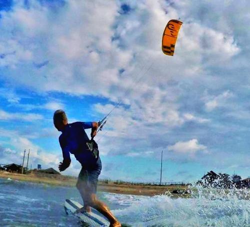 ルイース・コヘイアにあるCasa Azul do Piauíの凧を持った水上サーフボードの男