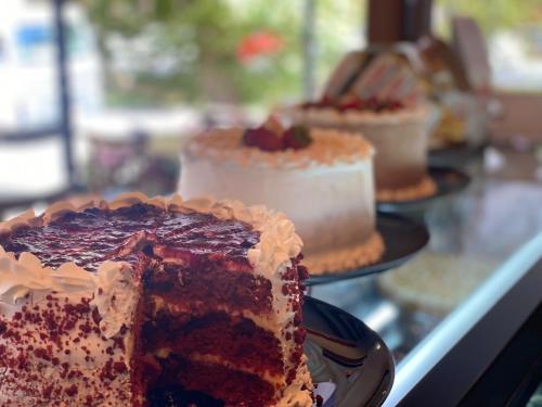 a piece of cake on a plate on a counter with other cakes at Casa Três Rios - Campos do Jordão in Campos do Jordão