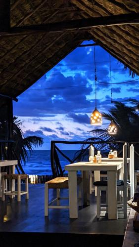 a white table and chairs with a view of the ocean at Pousada Casa Azul do Piauí in Luis Correia