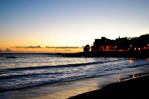 バジェ・グラン・レイにあるCasa Domingoの日没時の海と家のあるビーチ