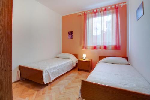 - 2 lits dans une petite chambre avec fenêtre dans l'établissement Apartment Mali Losinj 7879d, à Mali Lošinj