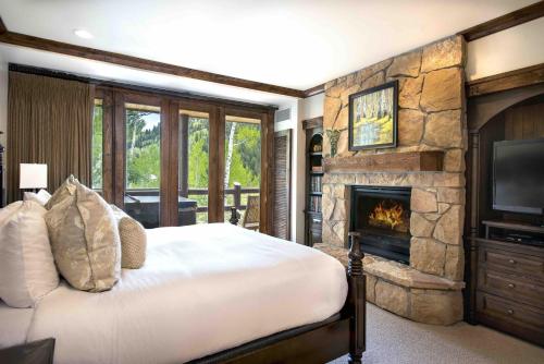 a bedroom with a bed and a stone fireplace at Junior King Suite Hotel Room in Park City