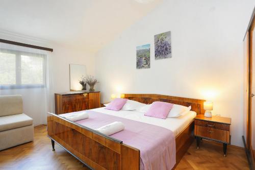 ein Schlafzimmer mit einem großen Bett mit rosa Kissen in der Unterkunft Apartments by the sea Podgora, Makarska - 11432 in Podgora
