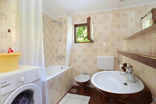 ein Badezimmer mit einer Waschmaschine und einem Waschbecken in der Unterkunft Apartments by the sea Podgora, Makarska - 11432 in Podgora