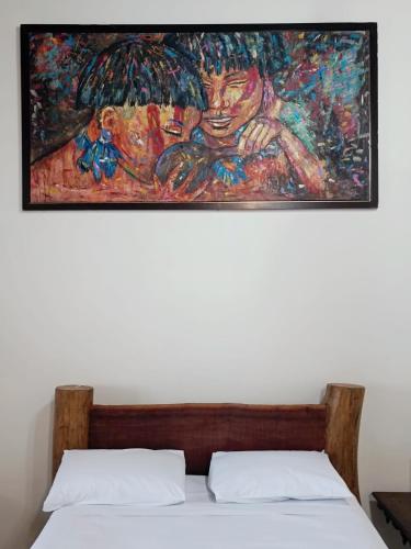 a painting above a bed in a bedroom at Brisa da Serra Hotel Pousada Pirenopolis in Pirenópolis