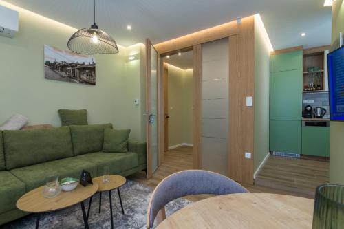 a living room with a green couch and a table at Mayisa Apartments in Sarajevo